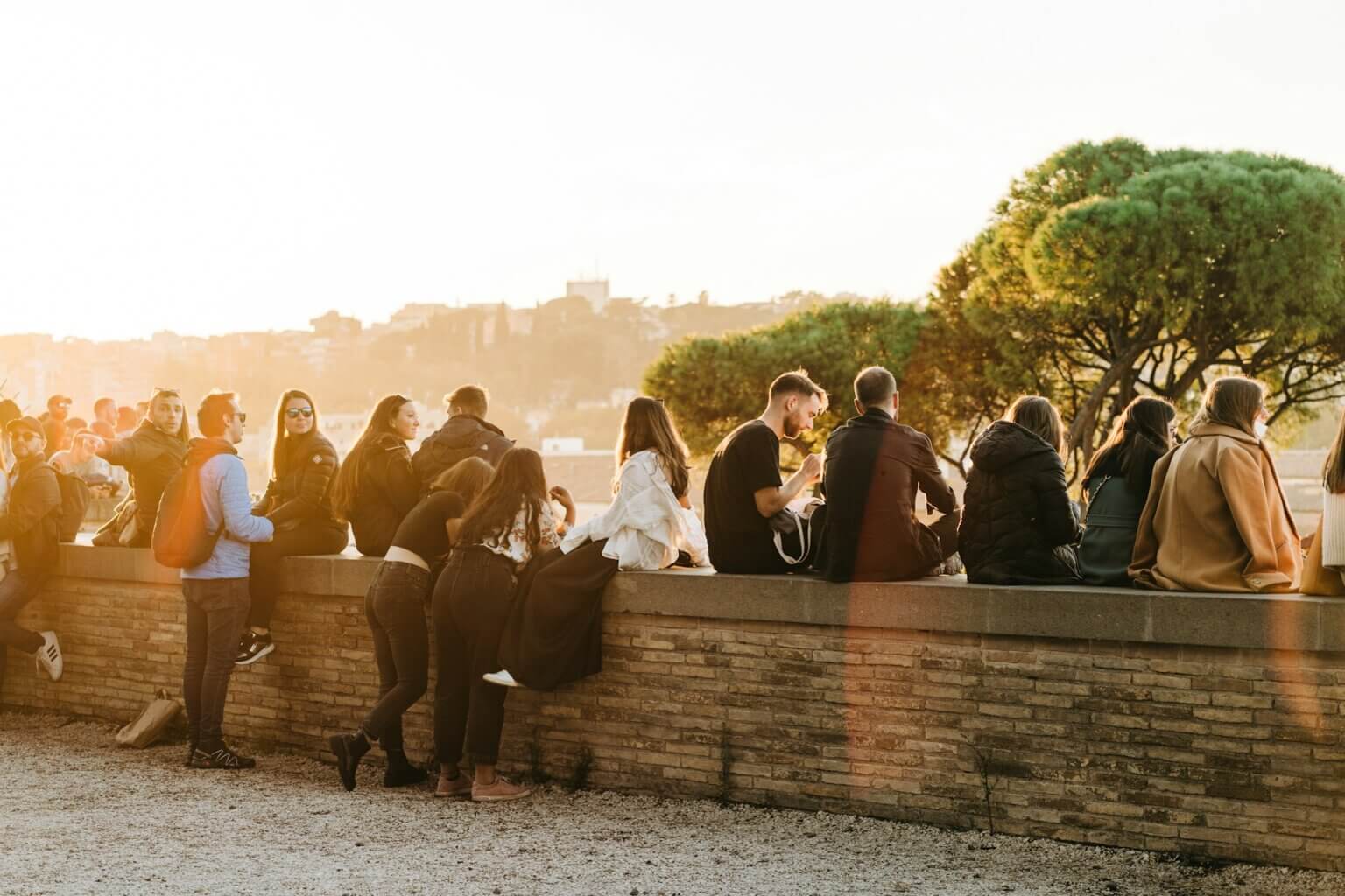 people relaxing together on a wall sunset